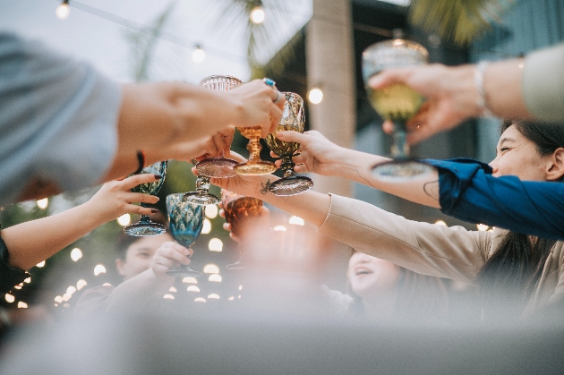 A group of people lifting their drinks in the air to celebrate