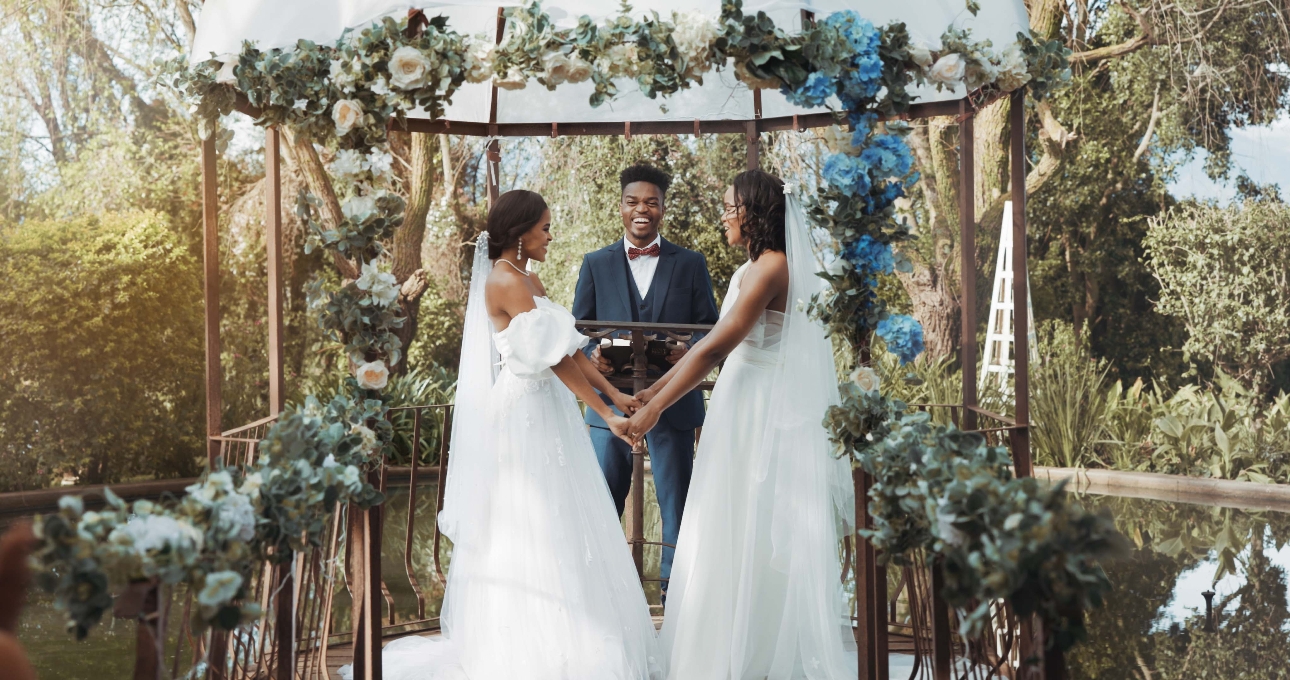 two brides tying the knot on a jetty over a lake