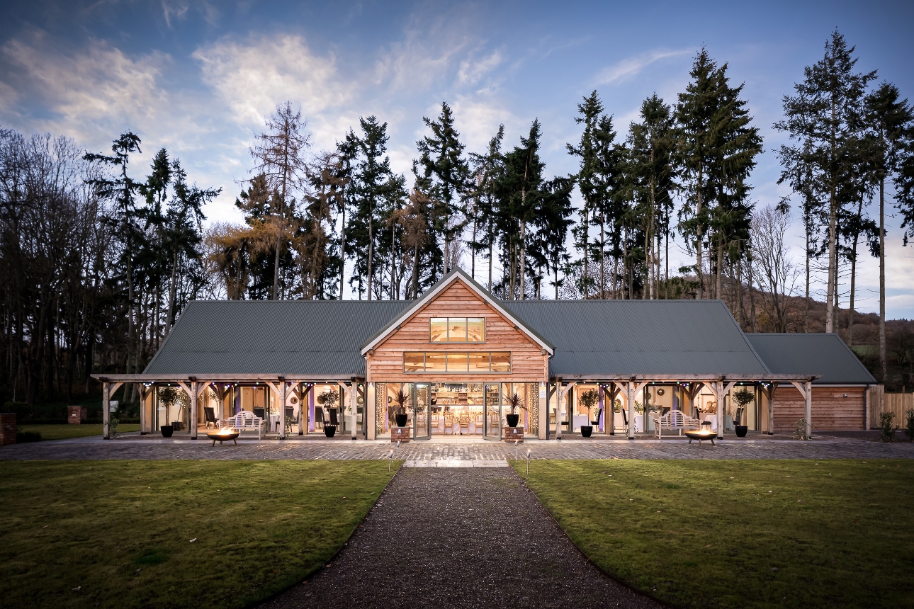 modern barn with tall trees in the background